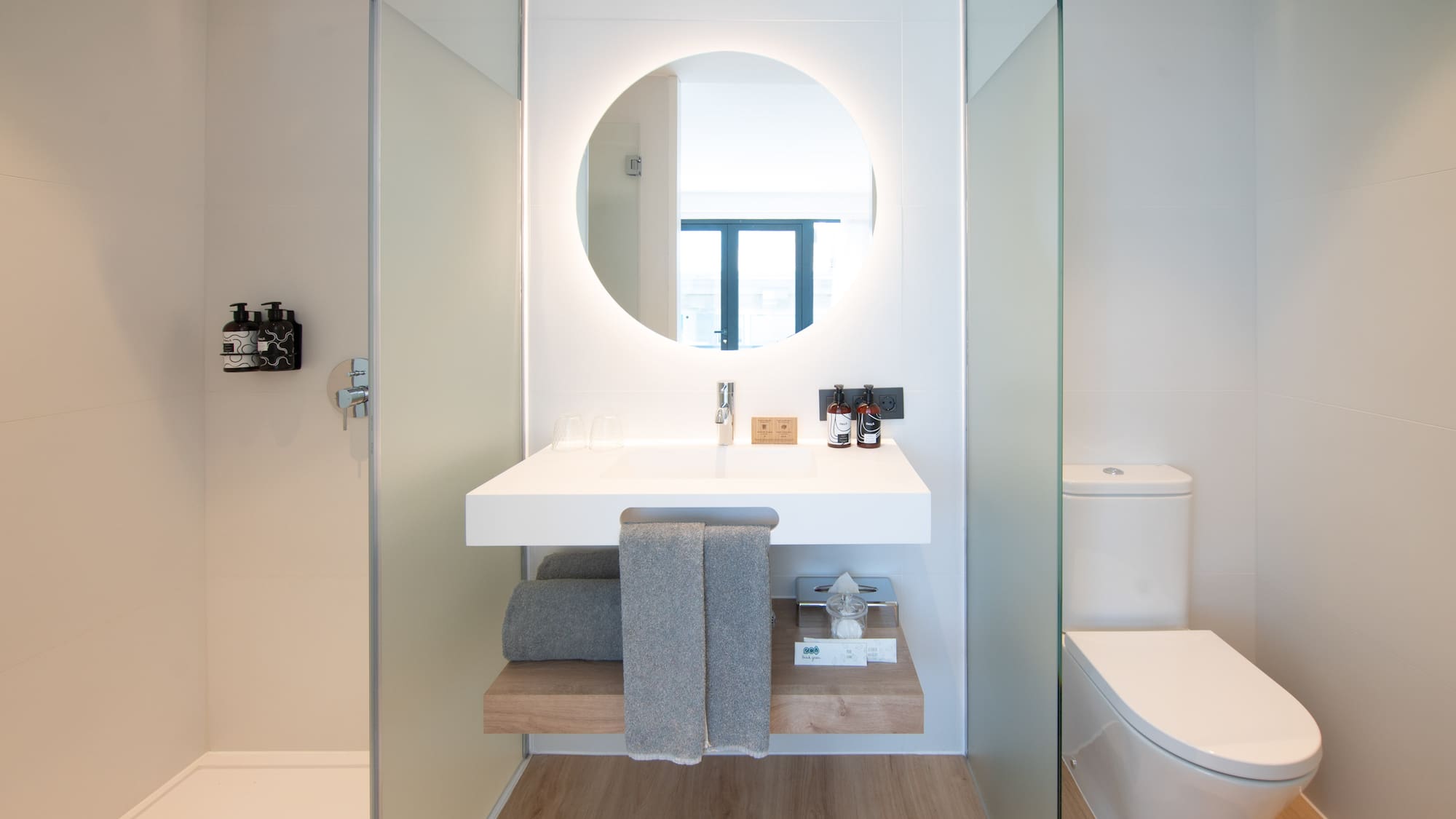 a bathroom with a round mirror and a toilet