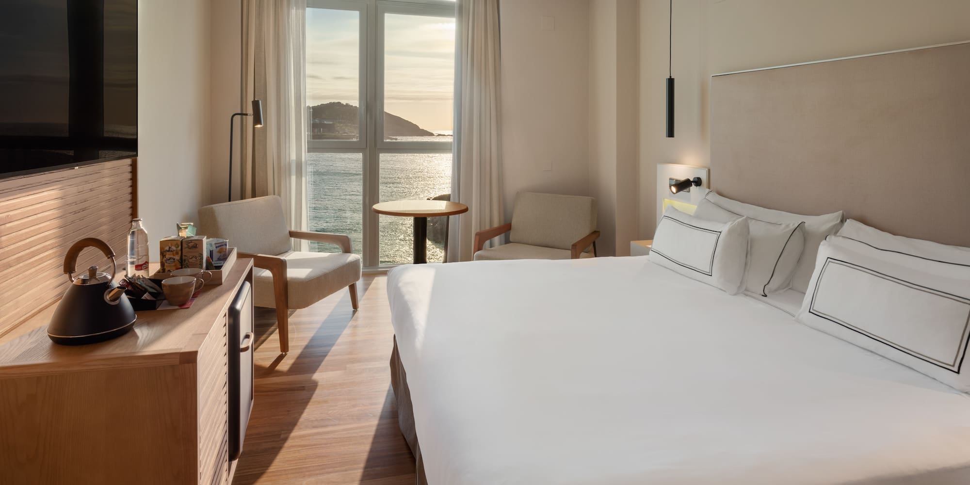 a room with a large bed and a table and chairs