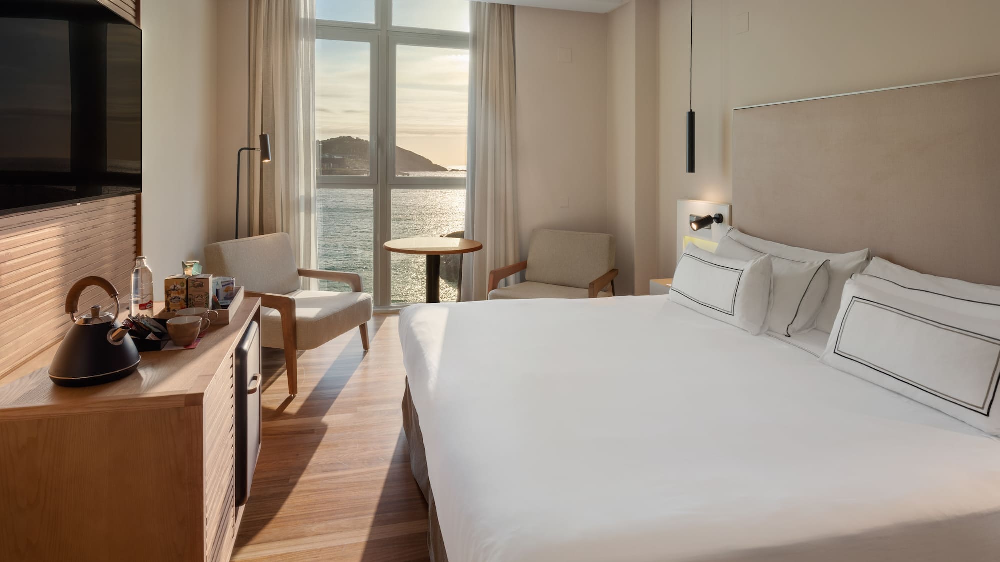 a room with a large bed and a table and chairs