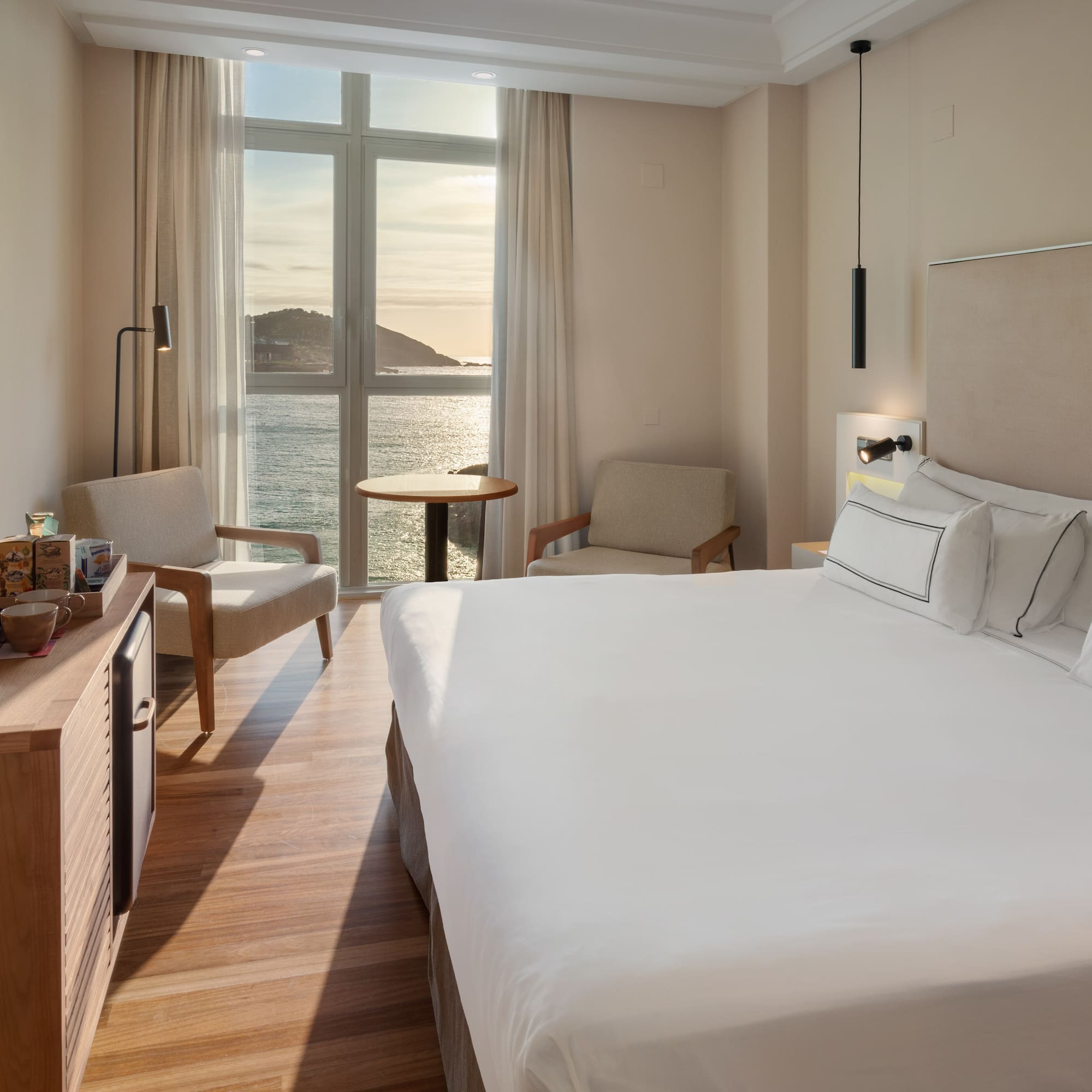 a room with a large bed and a table and chairs