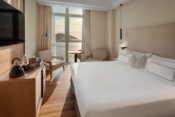 a room with a large bed and a table and chairs