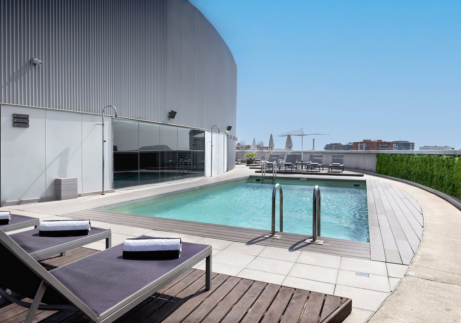 a pool with lounge chairs and a building in the background