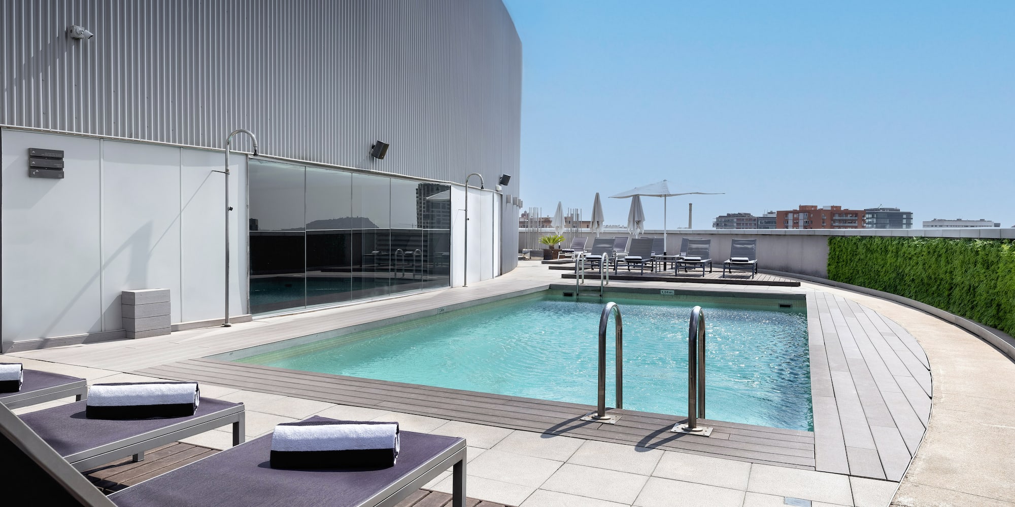 a pool with lounge chairs and a building in the background