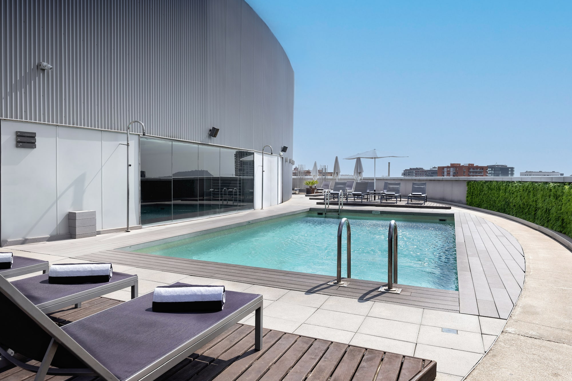 a pool with lounge chairs and a building in the background