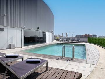 a pool with lounge chairs and a building in the background