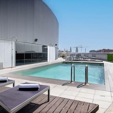 a pool with lounge chairs and a building in the background