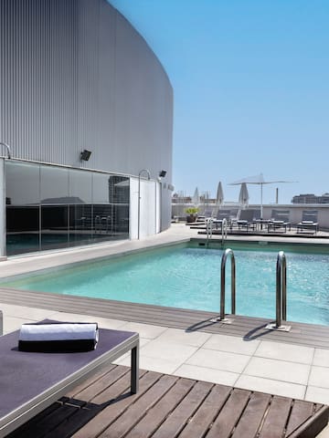 a pool with lounge chairs and a building in the background