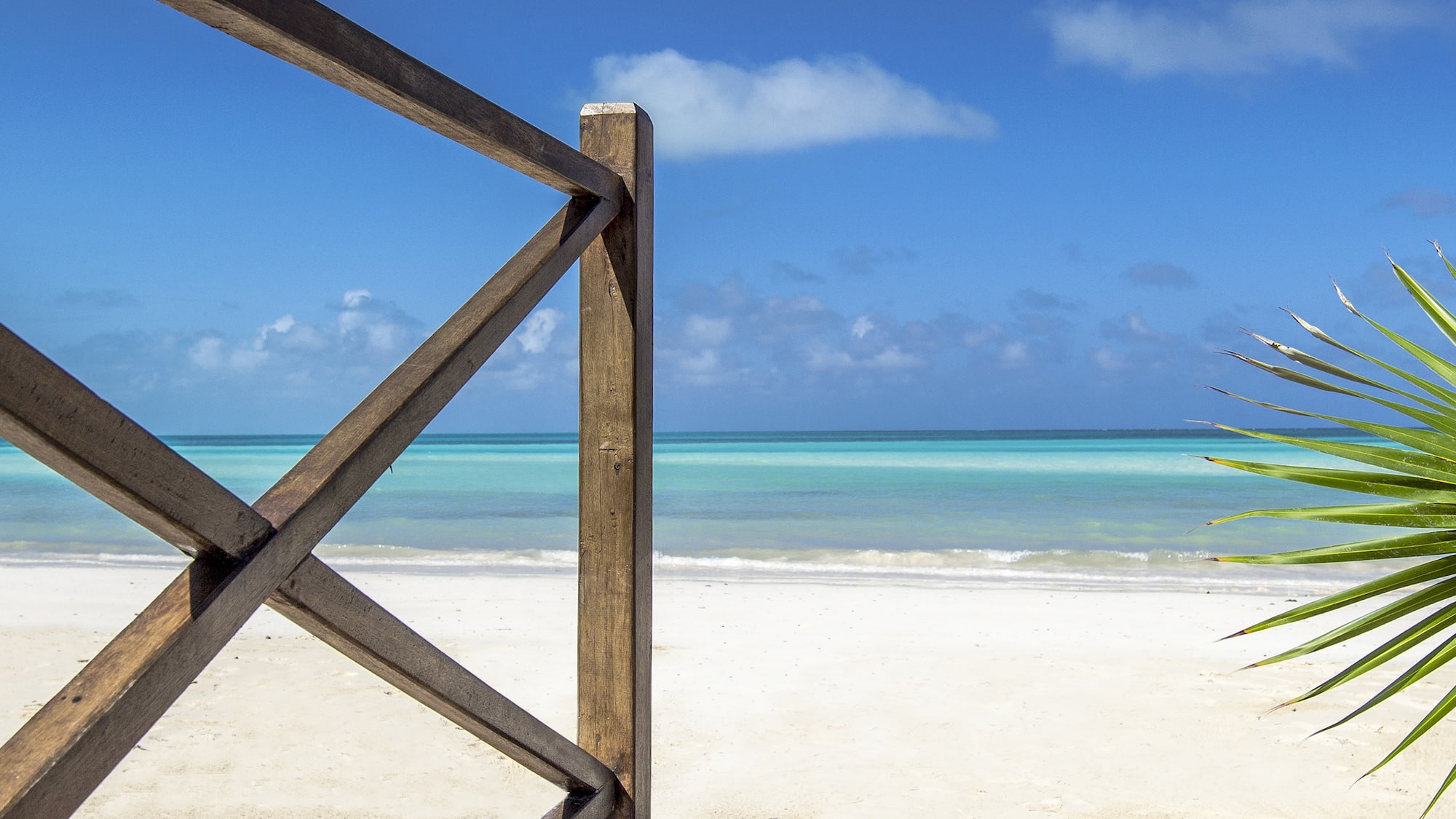 a wooden fence on a beach