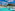 Resort swimming pool with palm trees, sun loungers, and blue water slide.