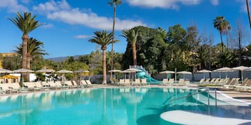 a pool with a slide and chairs