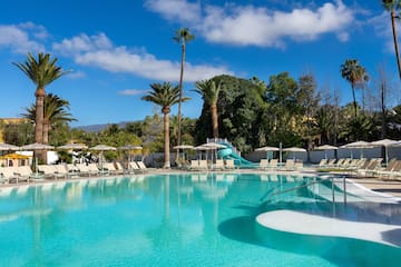 a pool with a slide and chairs