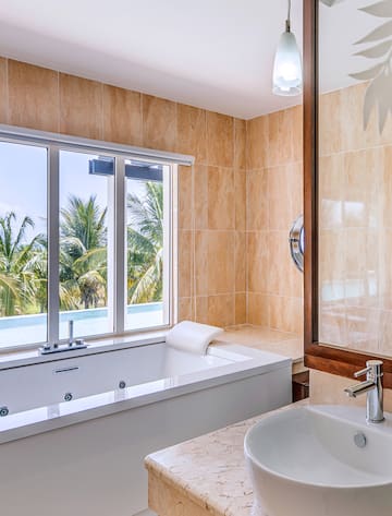 a bathroom with a tub sink and a window
