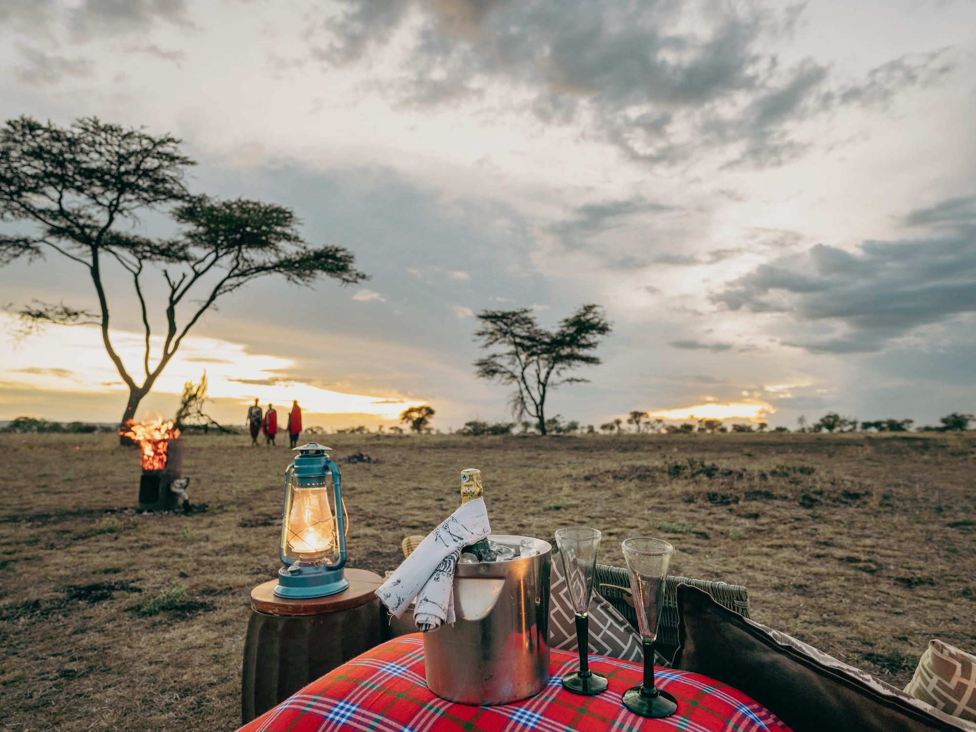 a picnic table with a lantern and a fire