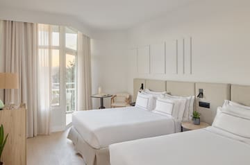 a room with two beds and a balcony