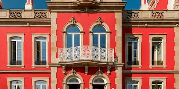 a gated driveway with trees and a house in the background