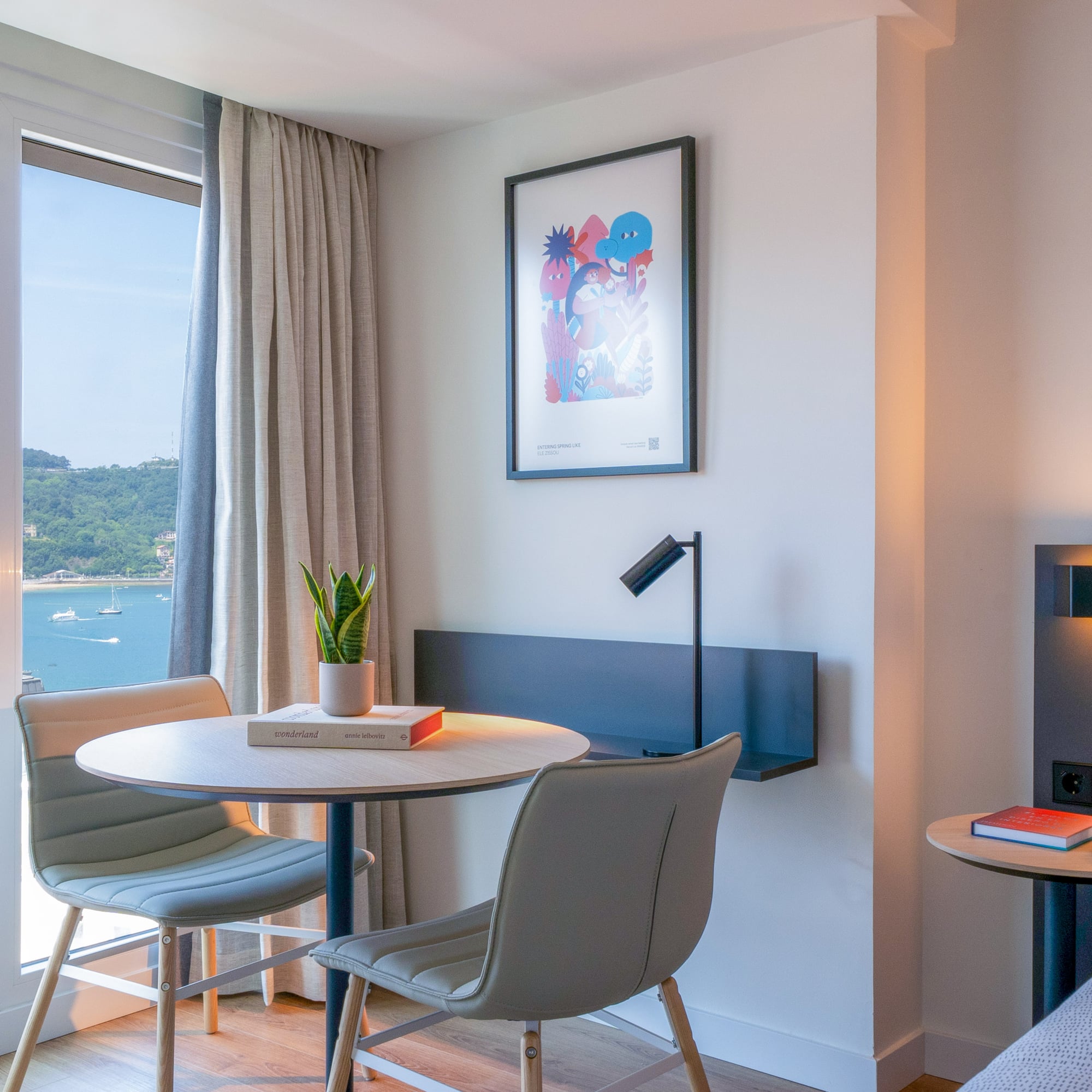 Habitación de hotel con vistas a la bahía, decoración moderna y mesa.