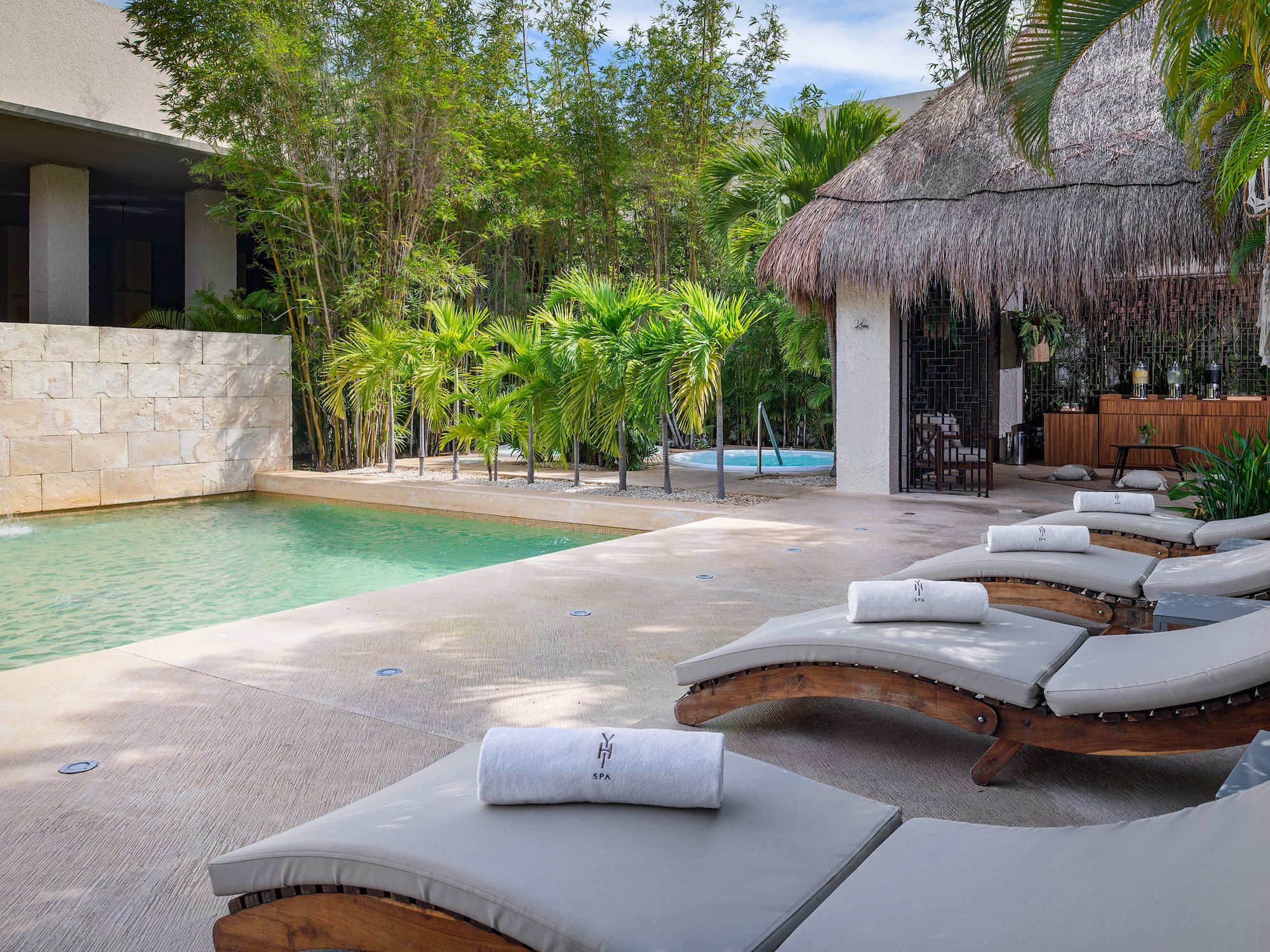 a pool with lounge chairs and a hut
