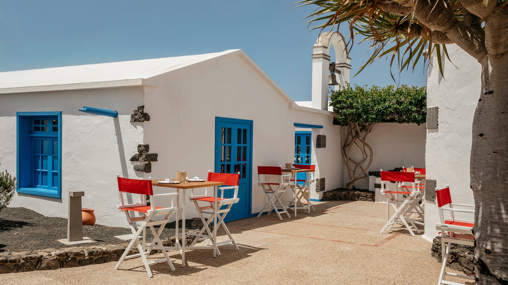 a white building with tables and chairs