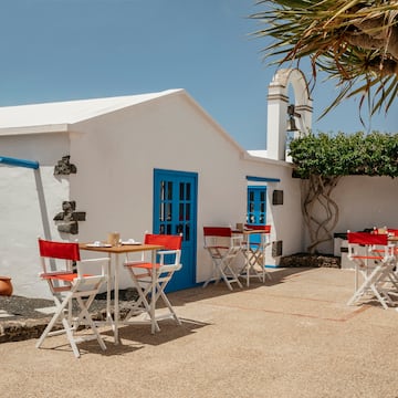 a white building with tables and chairs