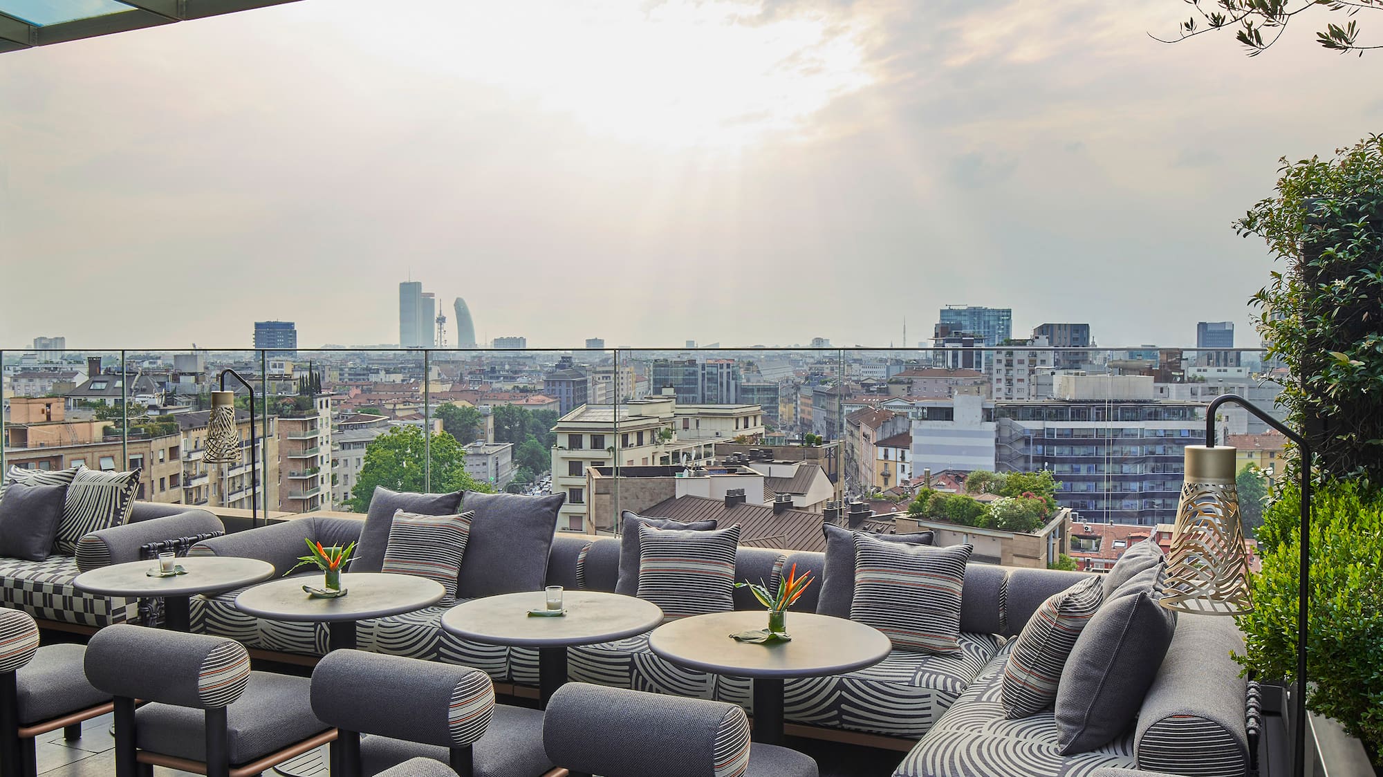 a patio with tables and chairs and a city view