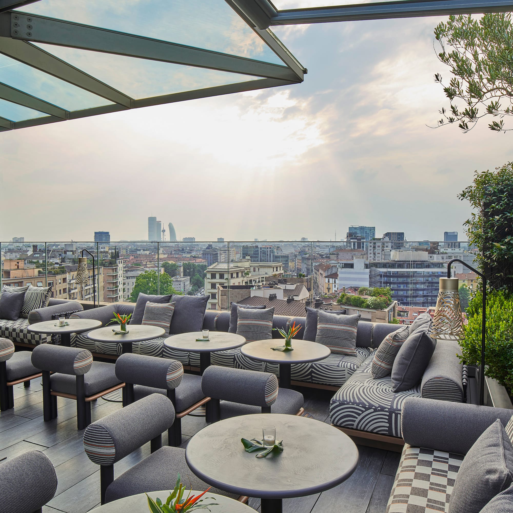 a patio with tables and chairs and a city view