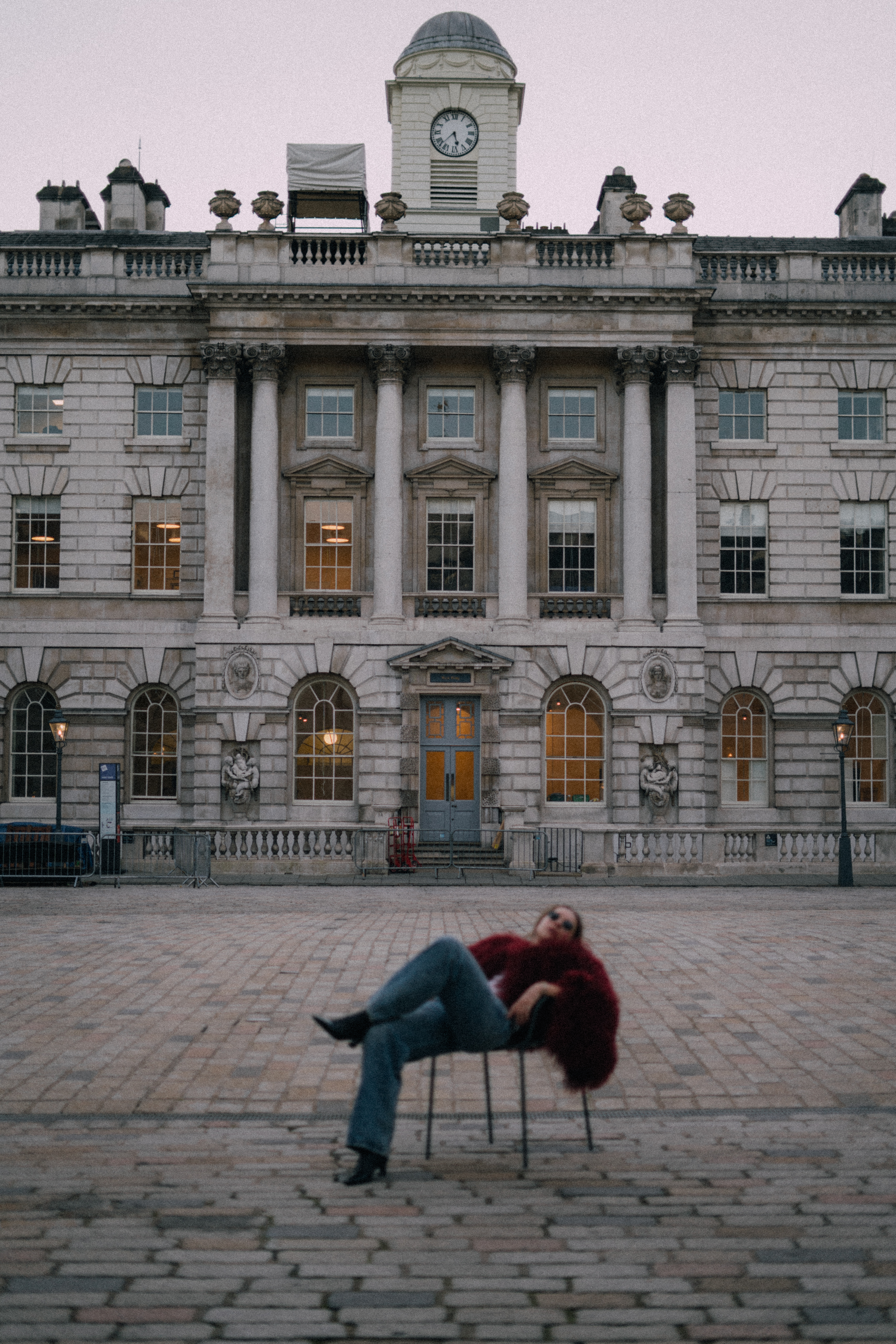a person sitting on a chair in front of a building