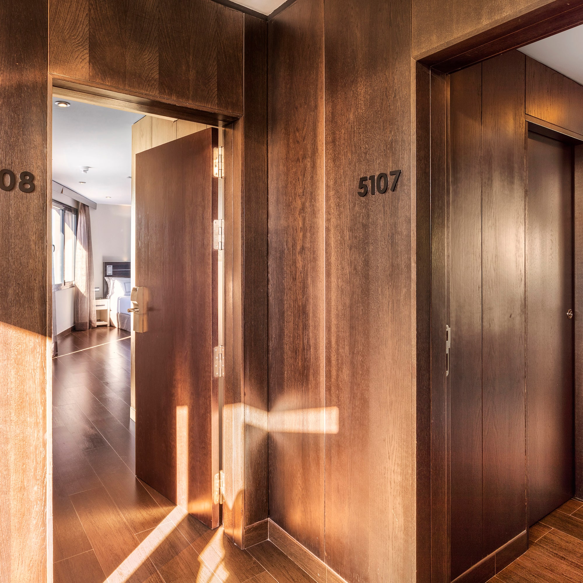 a hallway with doors and a wood floor