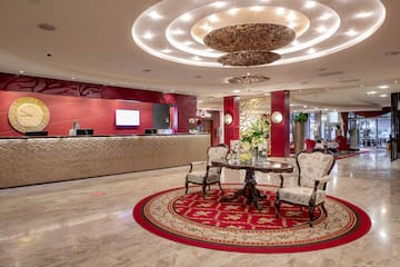 a lobby with a round red rug and a table with chairs