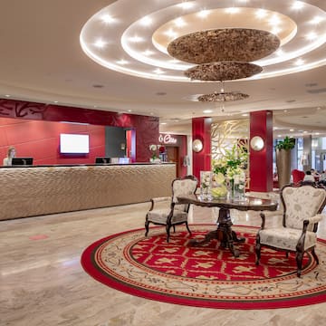a lobby with a round red rug and a table with chairs