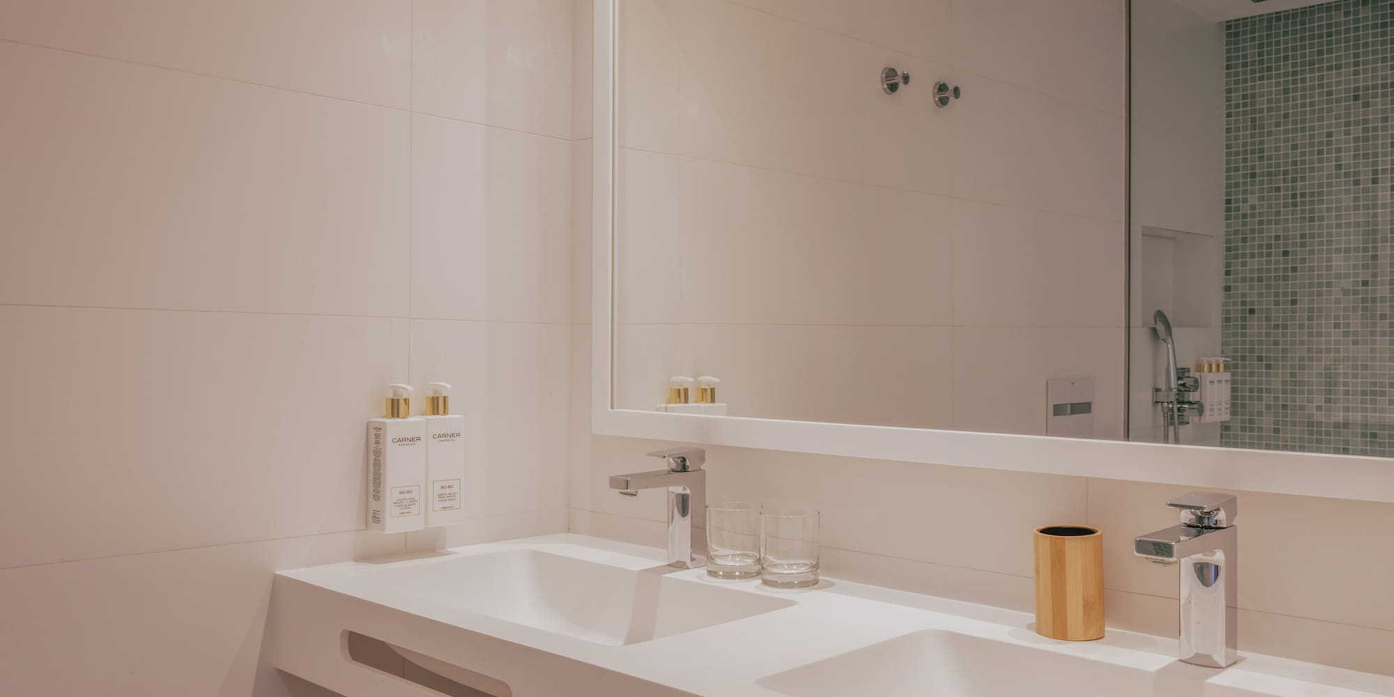 Modern double sink bathroom vanity, white countertop, chrome fixtures.