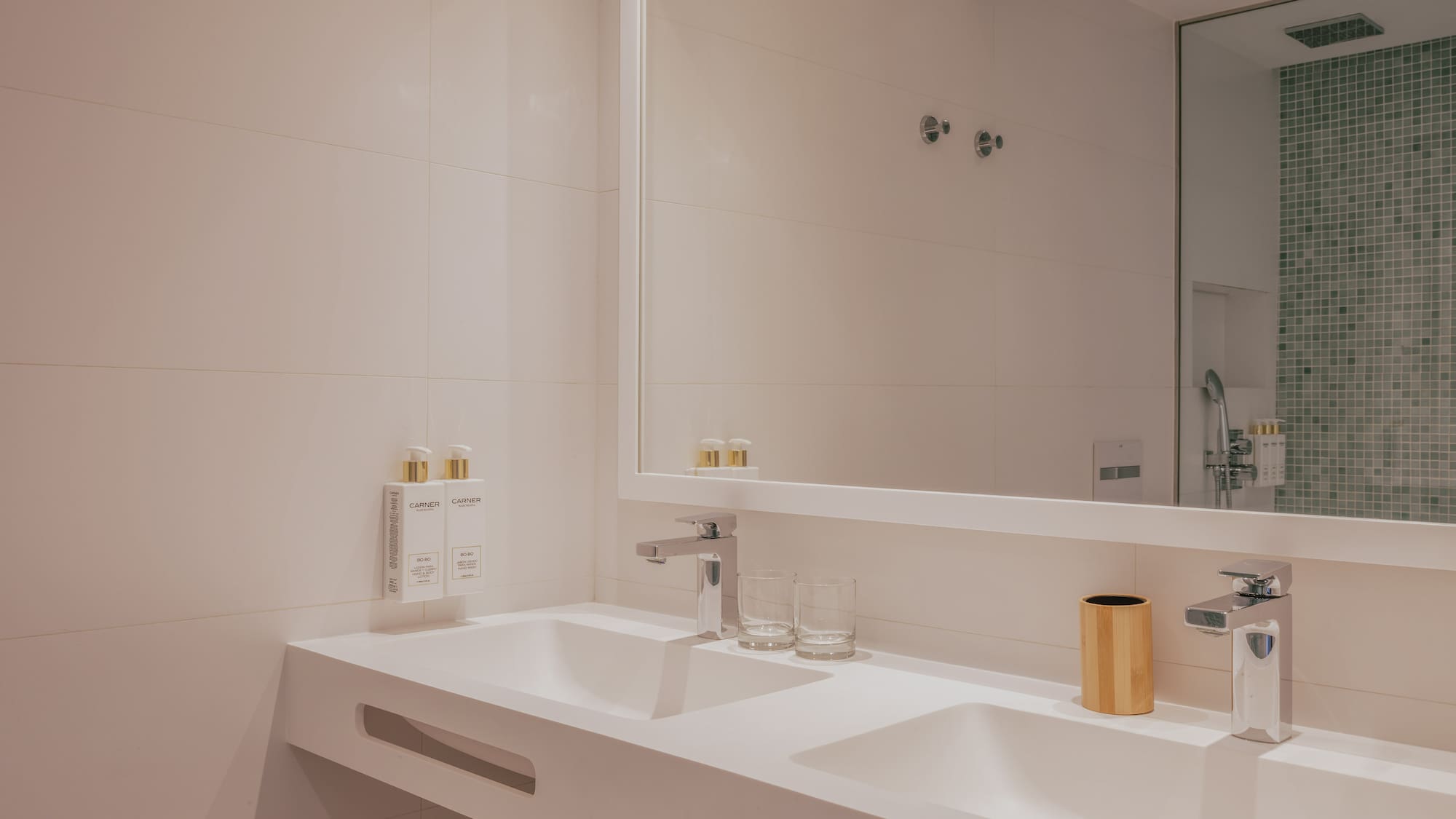 Modern double sink bathroom vanity, white countertop, chrome fixtures.