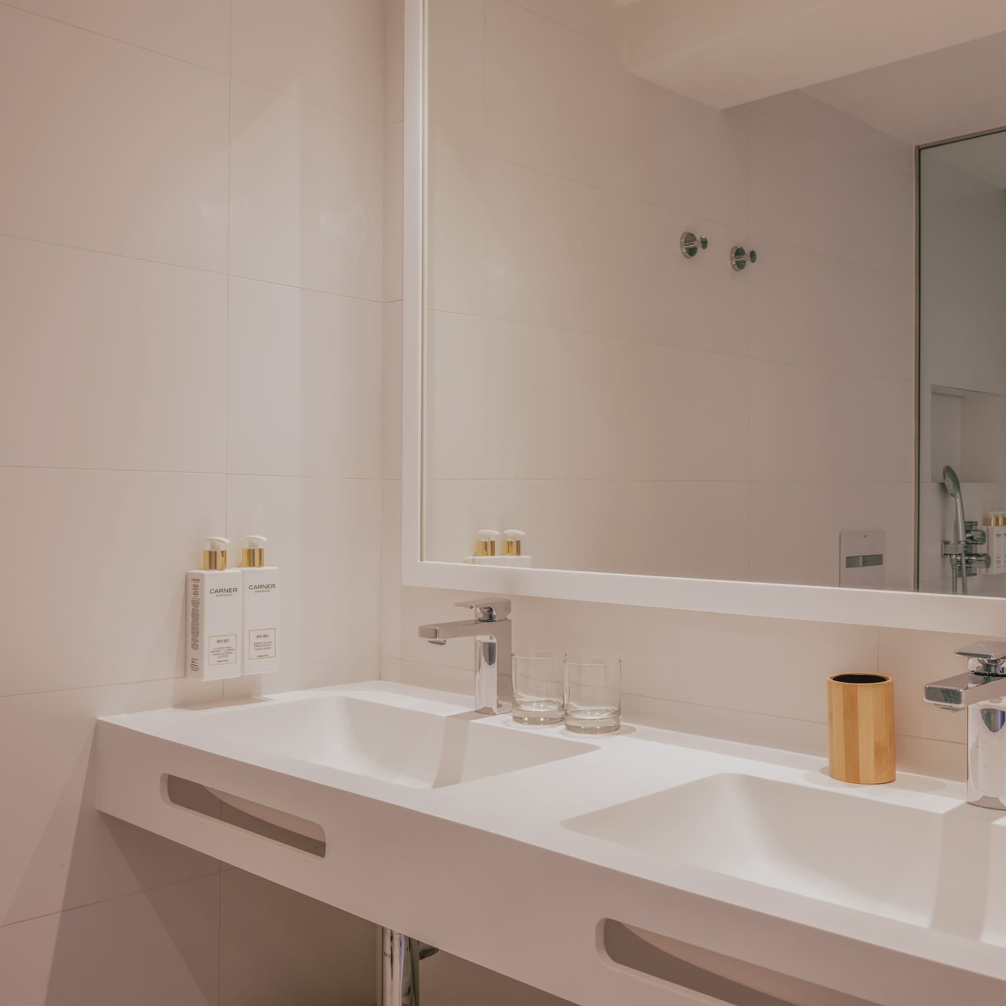 Modern double sink bathroom vanity, white countertop, chrome fixtures.