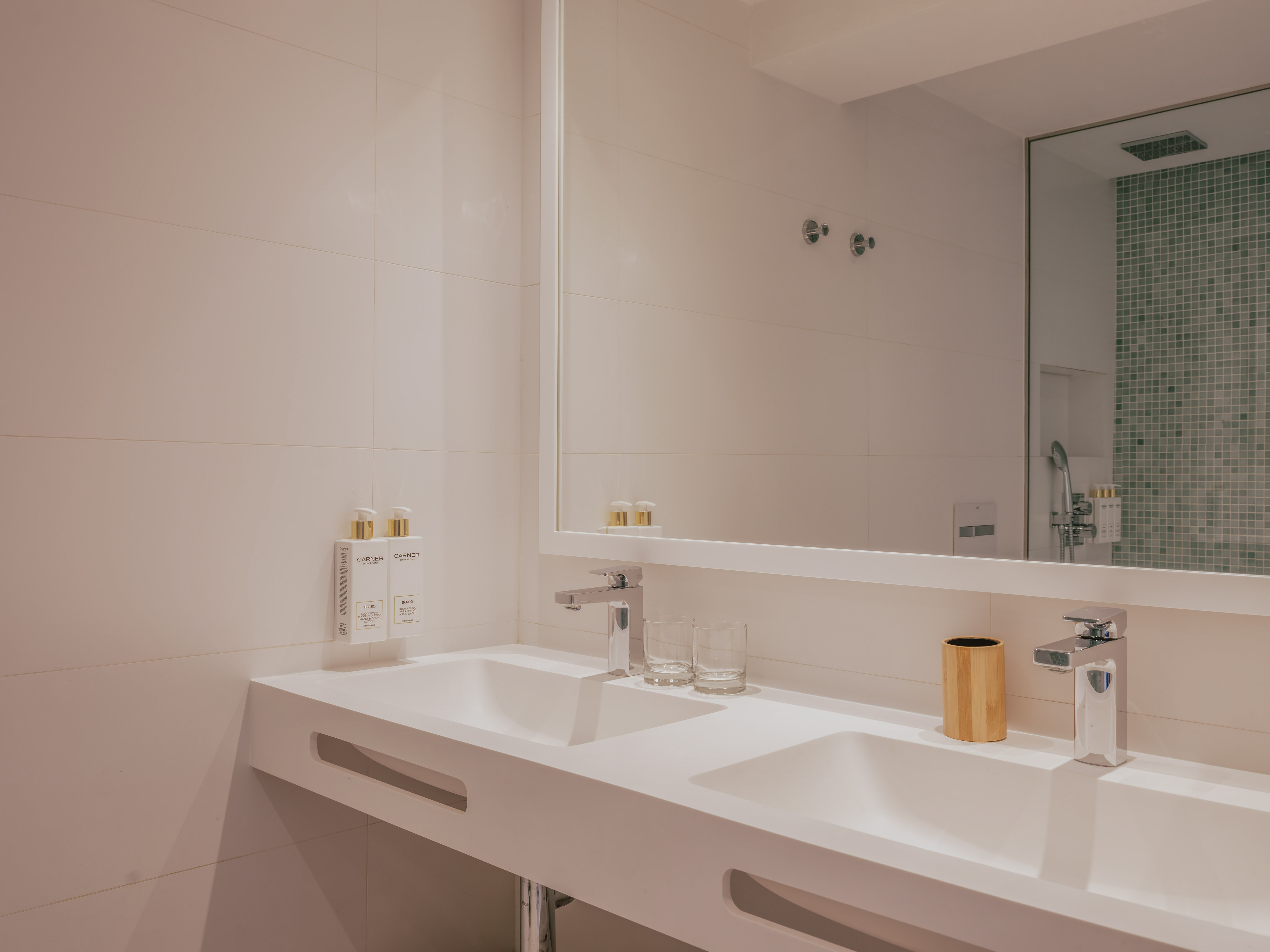 Modern double sink bathroom vanity, white countertop, chrome fixtures.