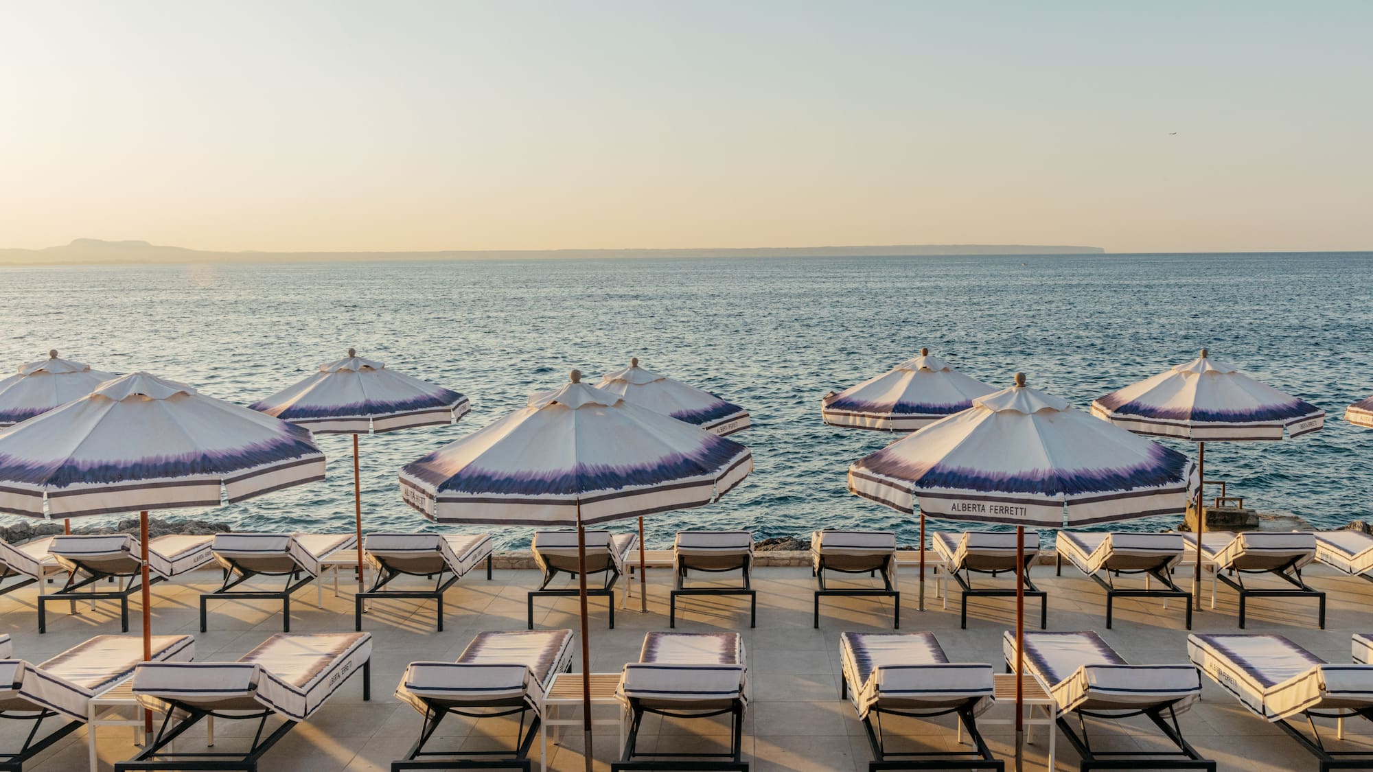 a beach with umbrellas and lounge chairs