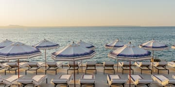 a beach with umbrellas and lounge chairs