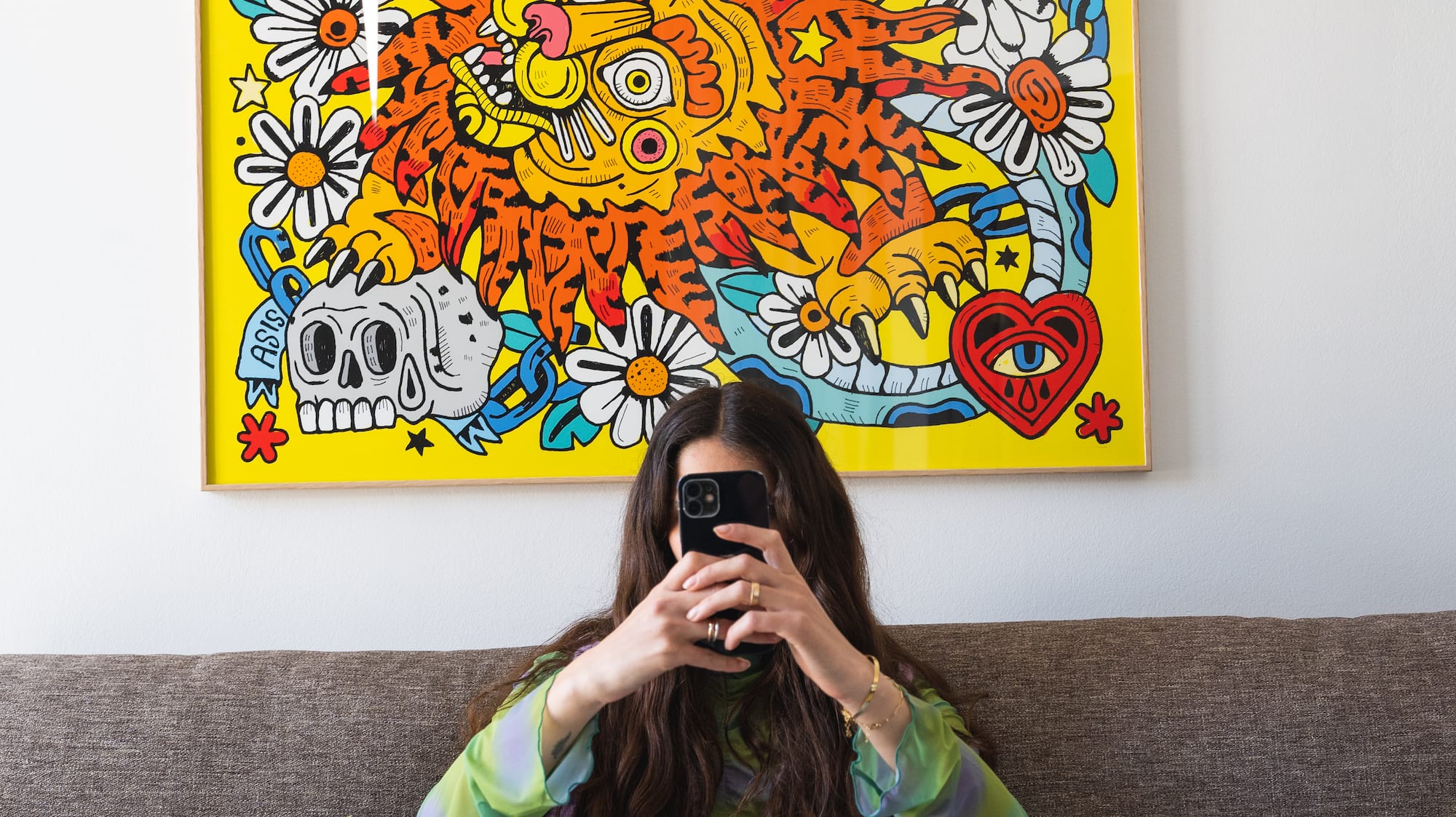 a woman sitting on a couch holding a camera