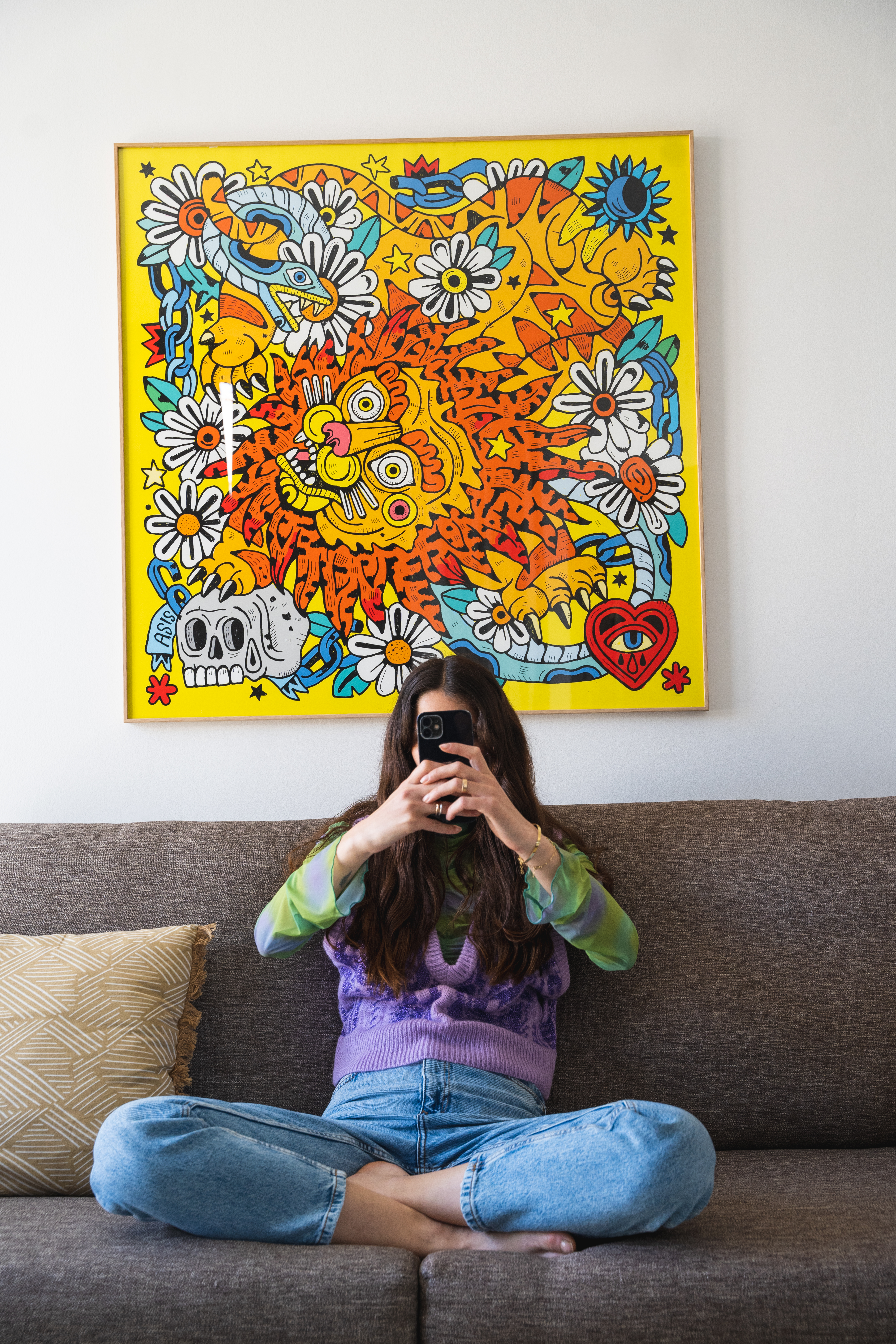 a woman sitting on a couch holding a camera