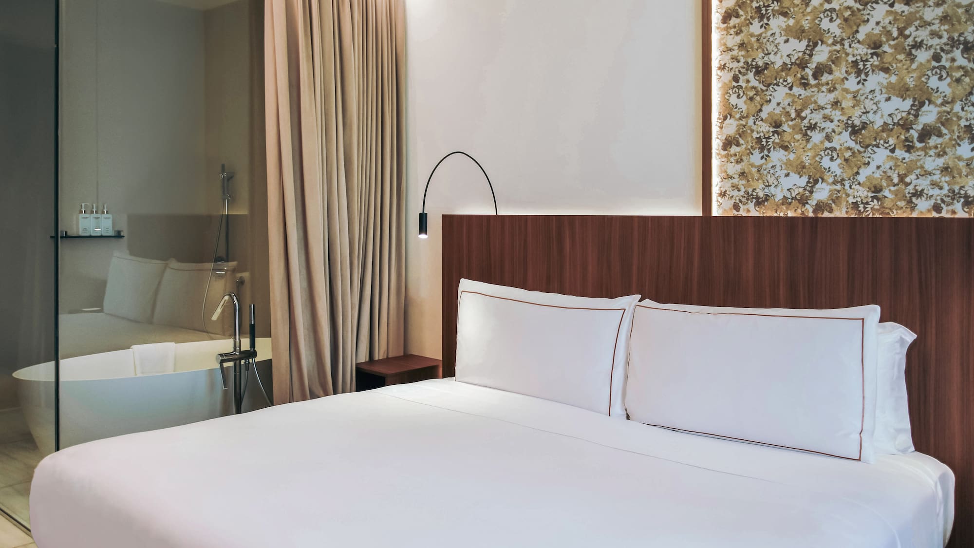 Twin bed with white sheets and a bathtub at the standard room from the Palazzo Cordusio Gran Melia Hotel