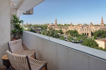 a balcony with chairs and trees