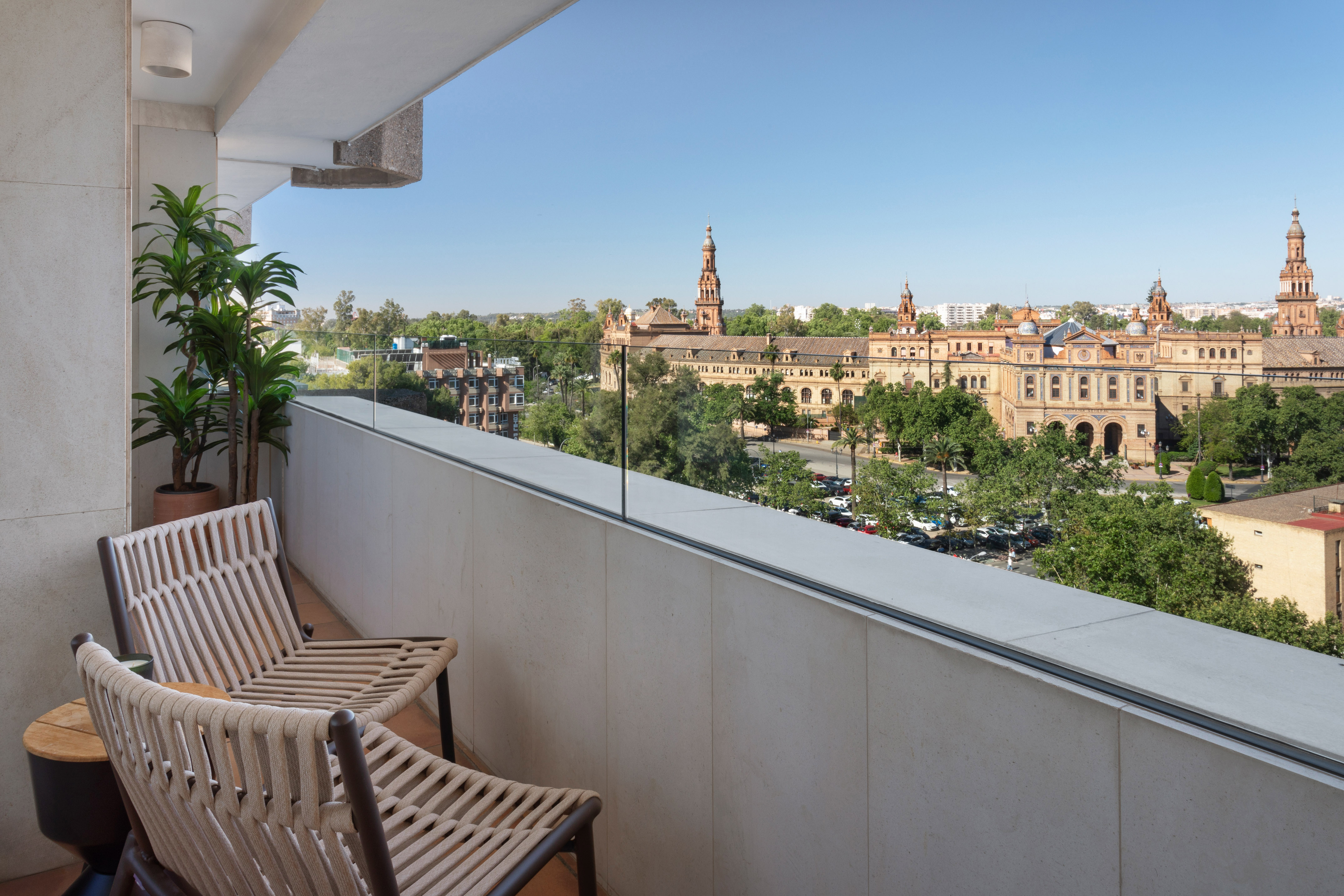 Modern balcony with chairs overlooking Plaza de España, Seville.