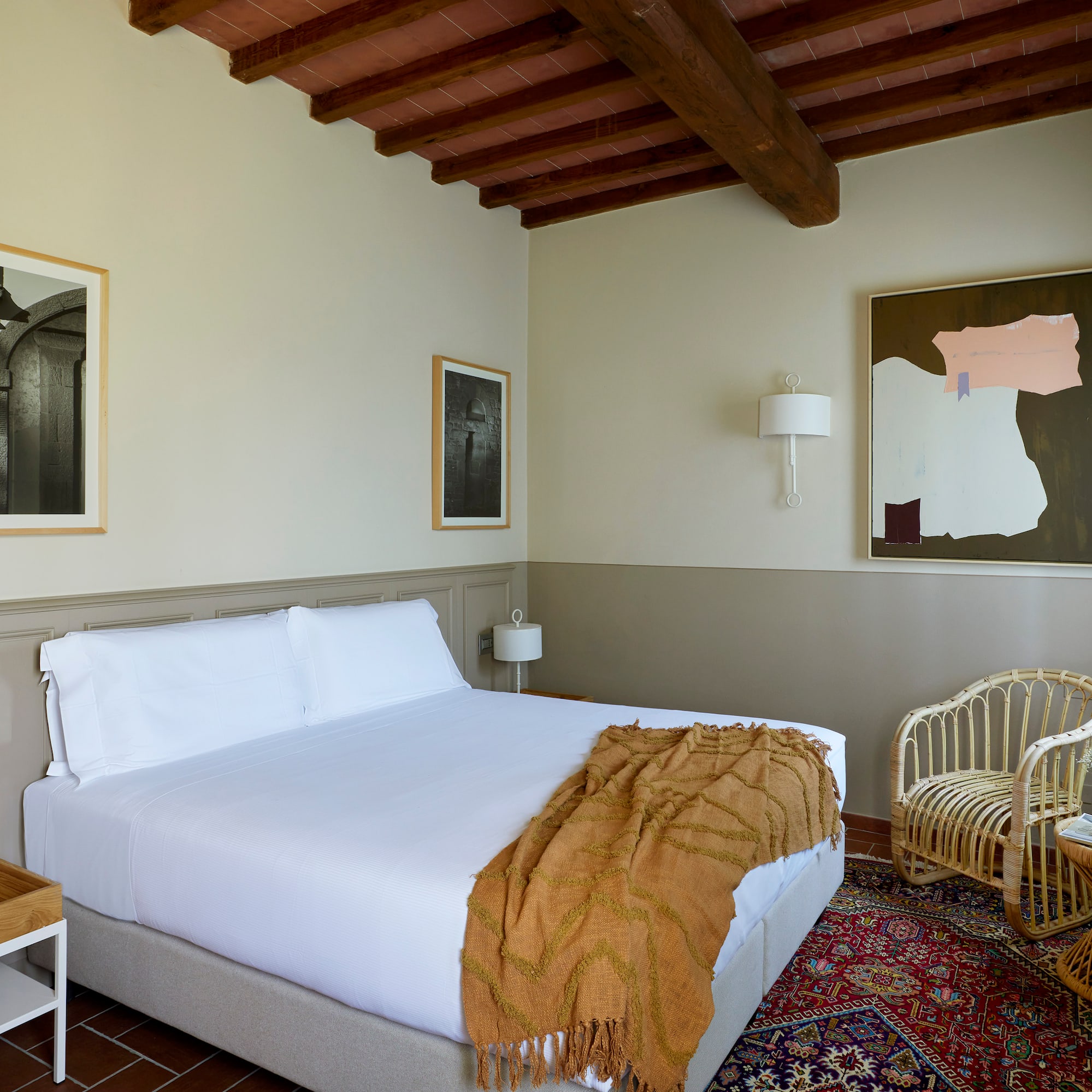 a bedroom with a bed and wicker chairs