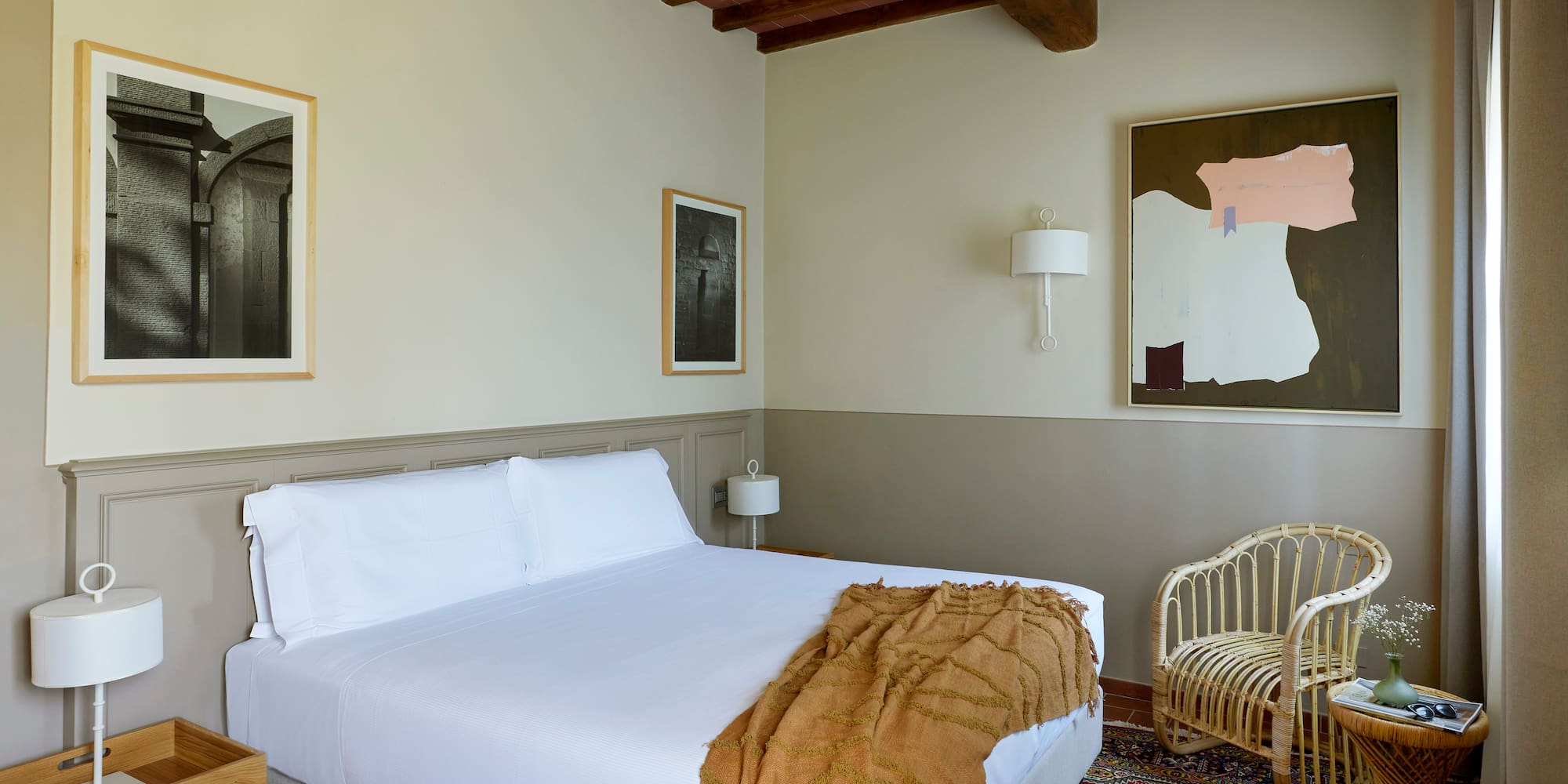 a bedroom with a bed and wicker chairs