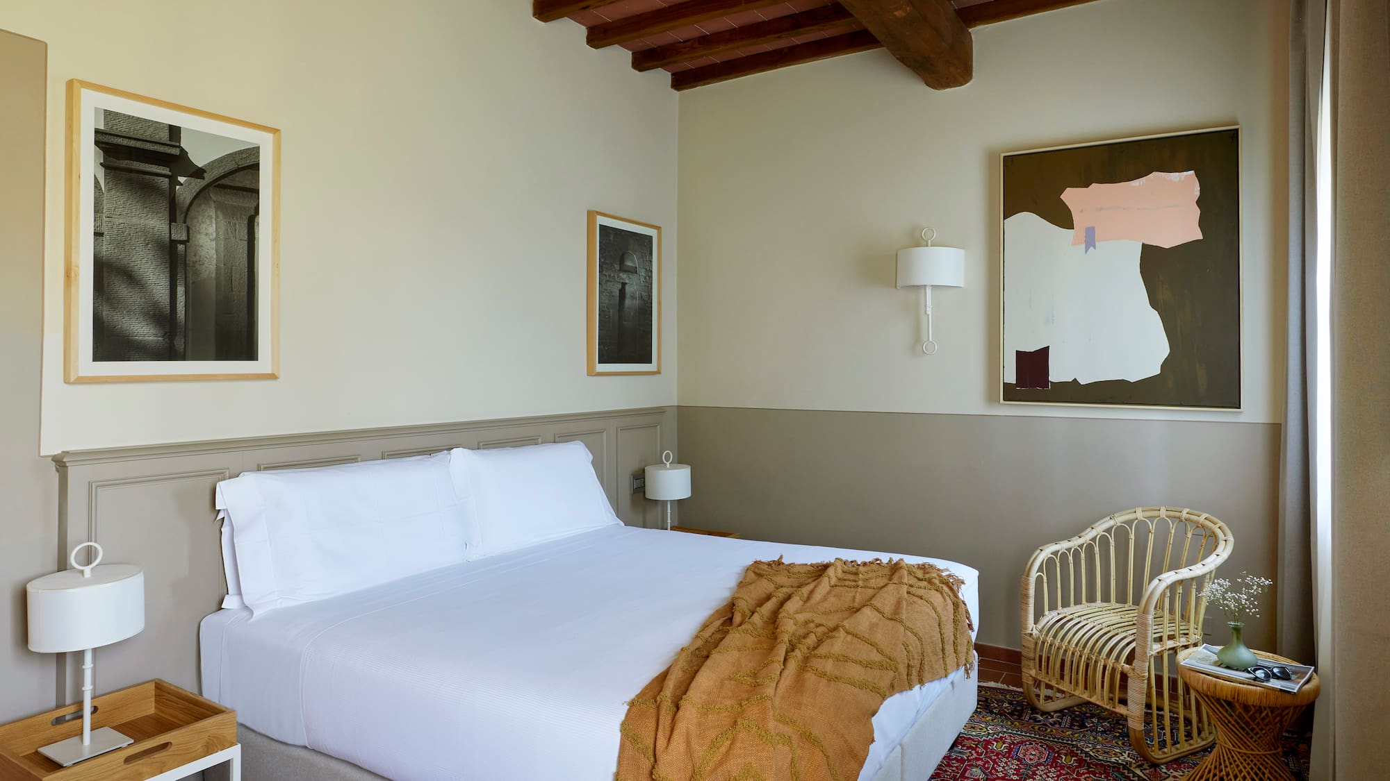 a bedroom with a bed and wicker chairs