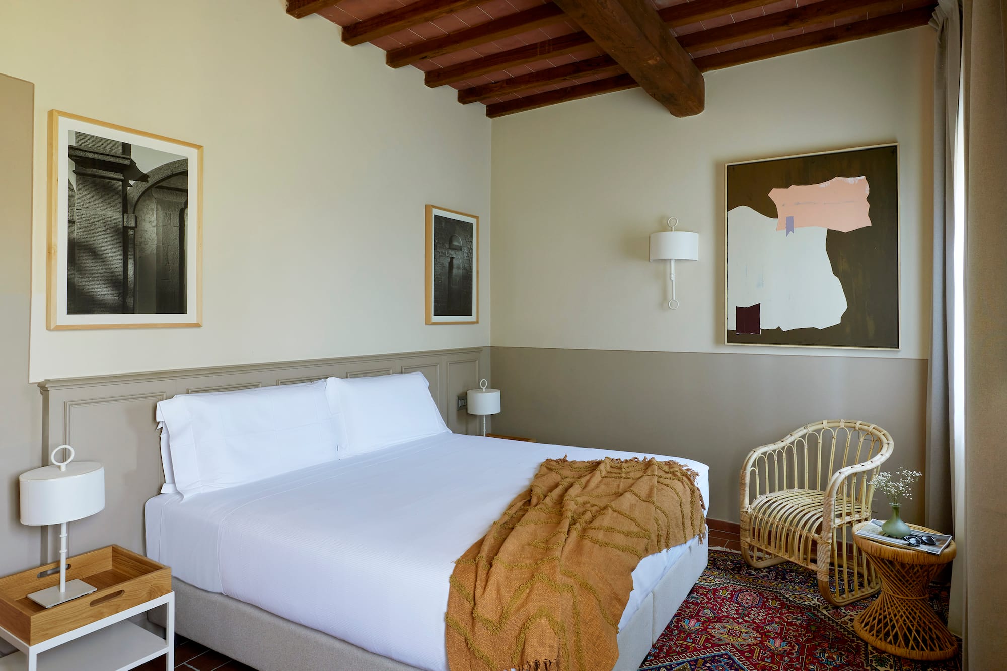 a bedroom with a bed and wicker chairs