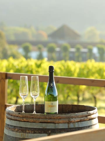 a bottle and two wine glasses on a barrel