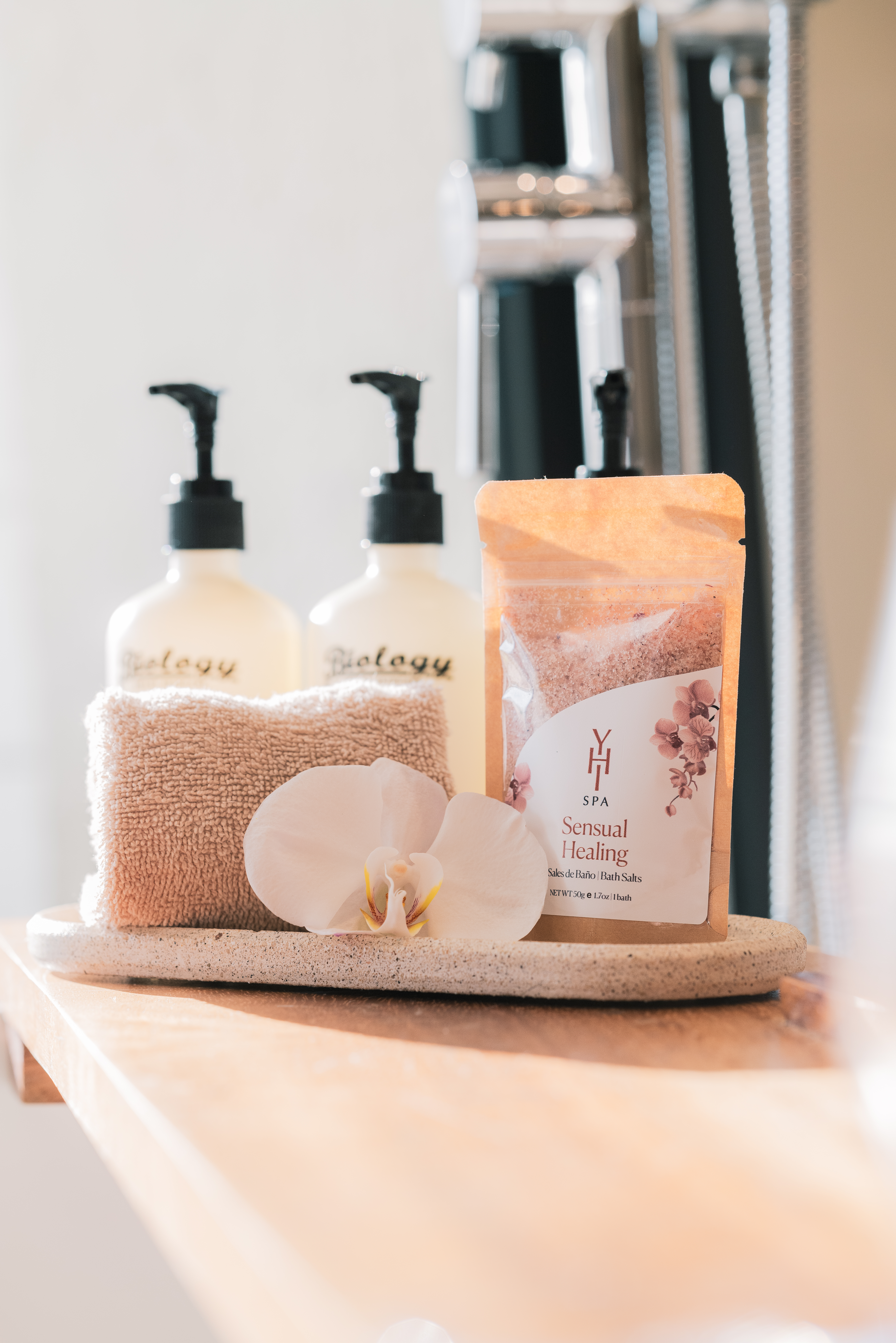 White orchid, folded towel, 'Sensual Healing' bath salts, and spa toiletries.