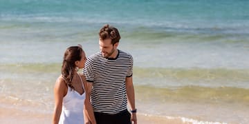 a man and woman walking on a beach
