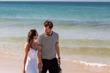 a man and woman walking on a beach