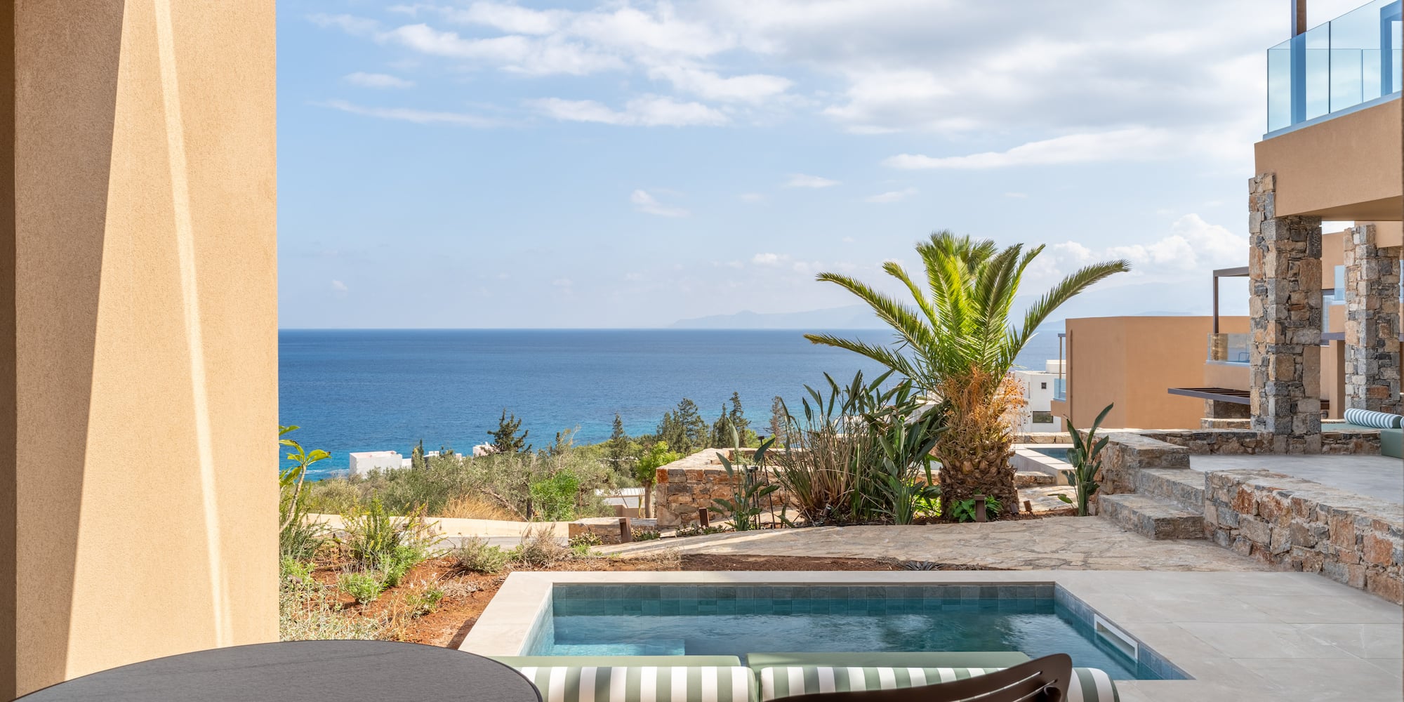 a pool with a table and chairs overlooking the ocean