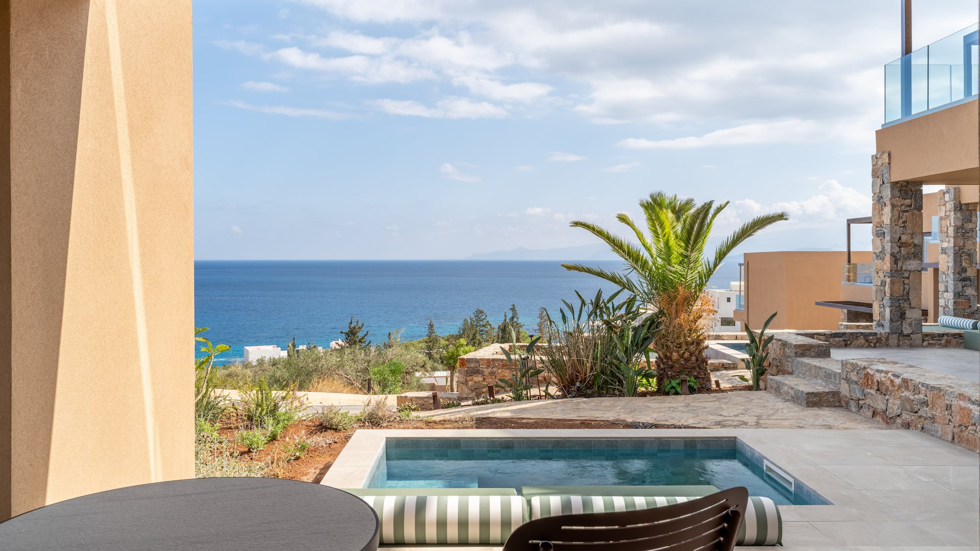 a pool with a table and chairs overlooking the ocean